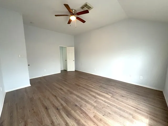 a view of empty room with wooden floor
