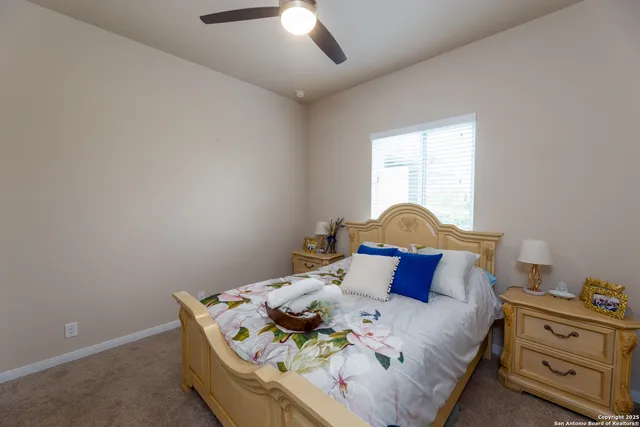 a bed sitting in a bedroom next to a window and a chandelier