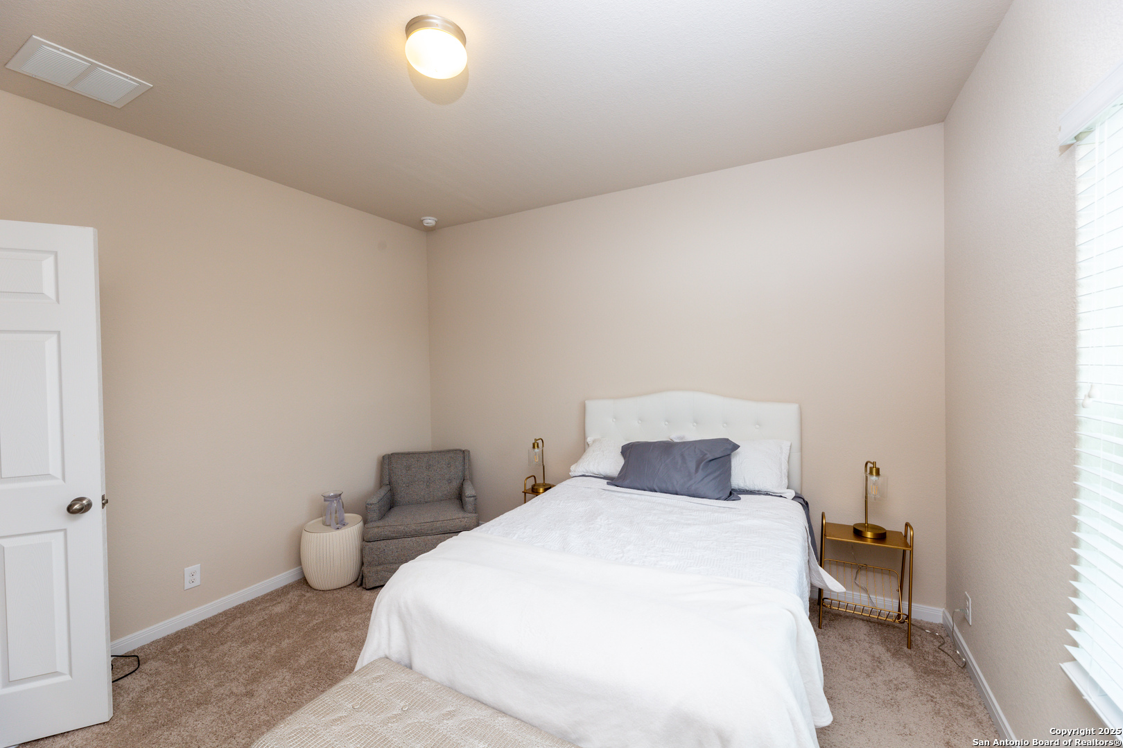 8701 Stackstone Schertz, TX 78154 - Photo 15 of 25 a bedroom with a bed and a lamp