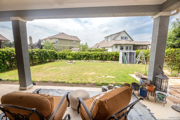 a view of a swimming pool with lawn chairs and a yard