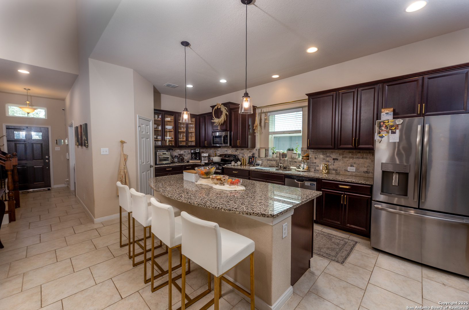 8701 Stackstone Schertz, TX 78154 - Photo 4 of 25 a kitchen with stainless steel appliances granite countertop wooden cabinets a refrigerator a sink a stove a microwave and island