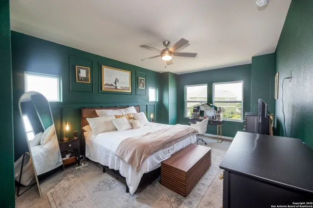 a bedroom with a large bed and a chandelier