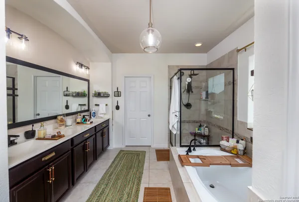 a spacious bathroom with a double vanity sink a mirror and a bathtub