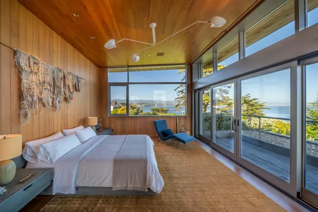 a bedroom with a bed and large window