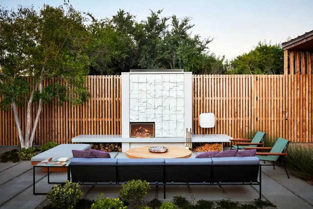 a backyard of a house with couches table and chairs