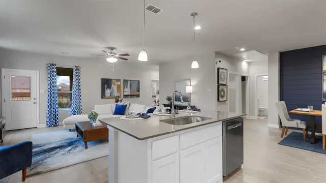a kitchen with refrigerator a stove a sink and chairs