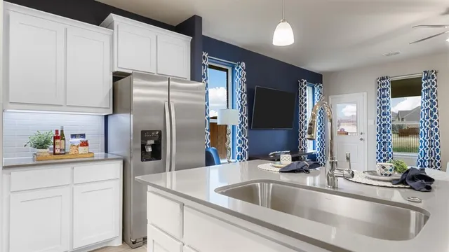 a kitchen with a sink appliances and a living room