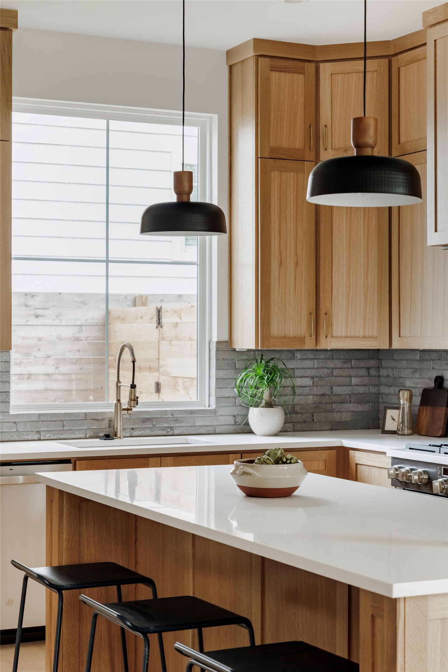 1180 Ridgeway Drive, Unit 2 Austin, TX 78702 - Photo 11 of 40 Kitchen featuring a kitchen bar, stainless steel dishwasher, decorative light fixtures, decorative backsplash, and gas stove
