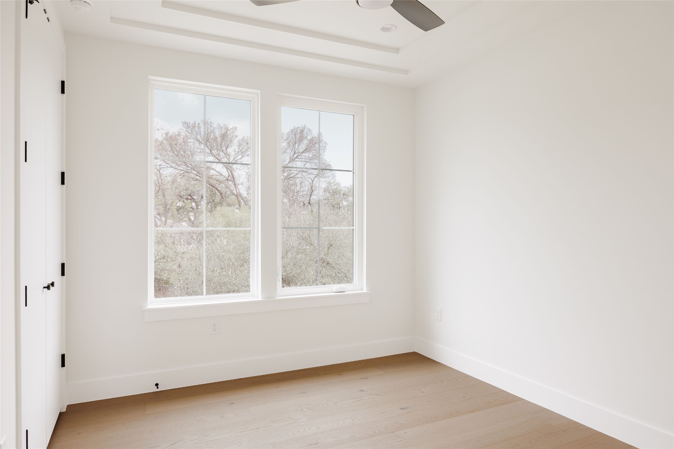 1180 Ridgeway Drive, Unit 2 Austin, TX 78702 - Photo 35 of 40 Spare room featuring light wood-style flooring, ceiling fan, and a tray ceiling