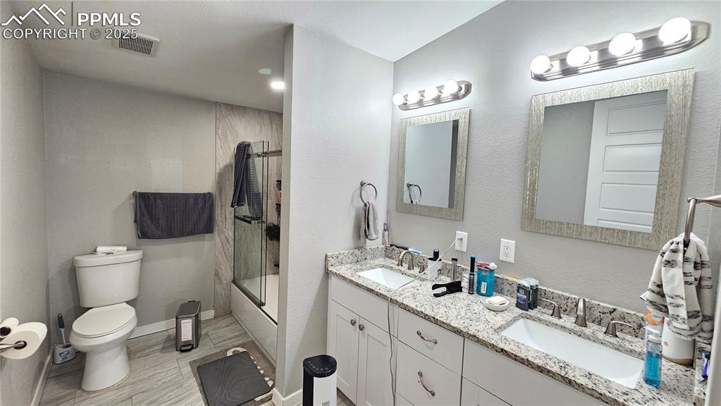 3835 Sengbeil Road Yoder, CO 80864 - Photo 21 of 48 Full bath with visible vents, bath / shower combo with glass door, a sink, and toilet