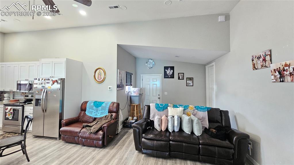 3835 Sengbeil Road Yoder, CO 80864 - Photo 10 of 48 Living room featuring visible vents, vaulted ceiling, and light wood-style flooring