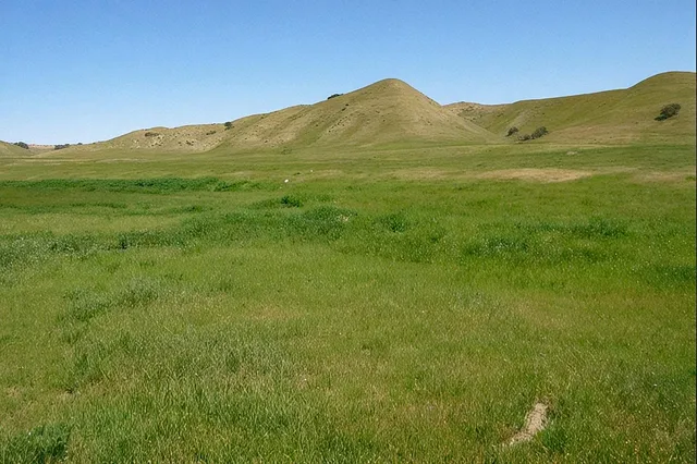 a view of a mountain range with an lush green hillside