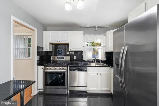 a kitchen with stainless steel appliances granite countertop a stove a refrigerator and a microwave