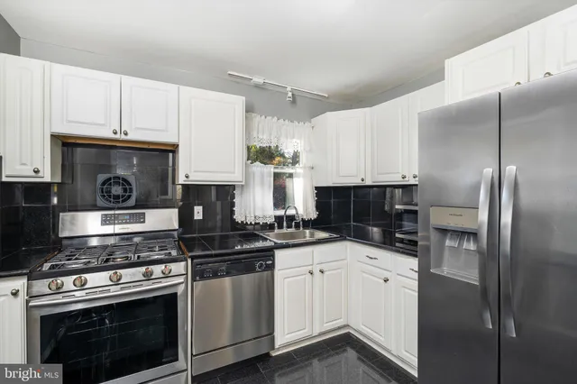 a kitchen with cabinets and stainless steel appliances