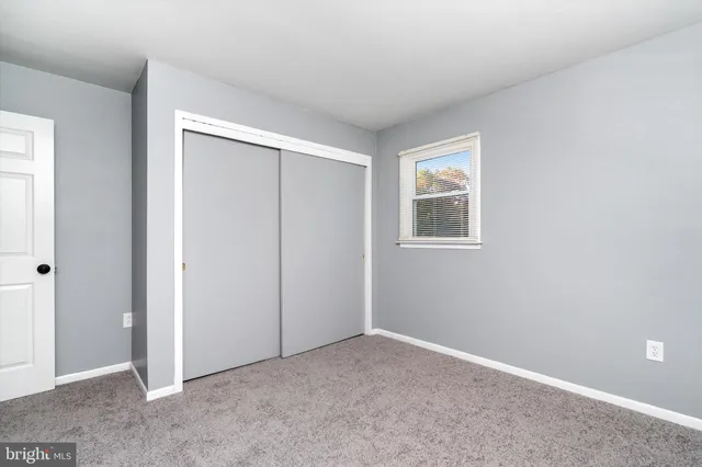 an empty room with windows and closet