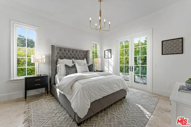 a bed room with a bed a television and a large window