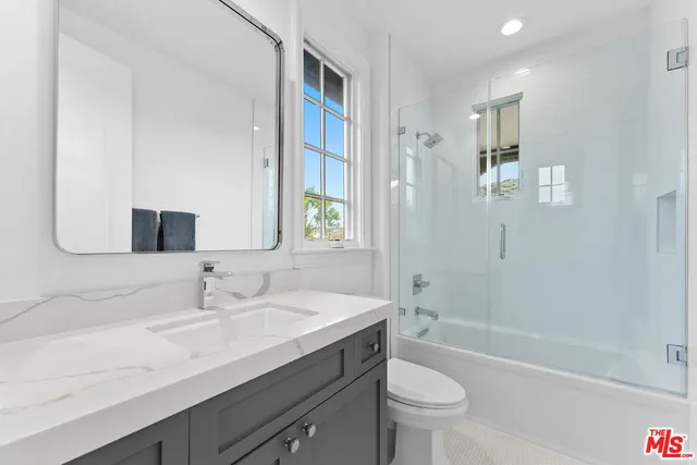 a patio with glass top table and chairs