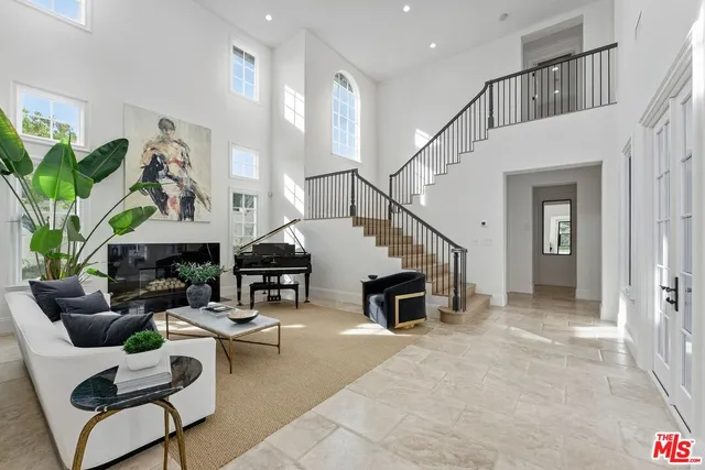 a living room with furniture flowers and a potted plant