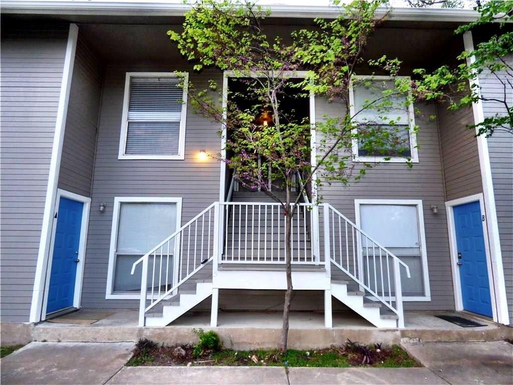 a view of a house with a yard and potted plants