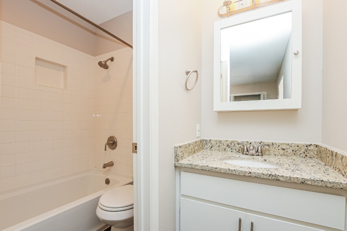 5201 Evans Avenue, Unit A Austin, TX 78751 - Photo 11 of 16 a bathroom with a granite countertop sink toilet and shower