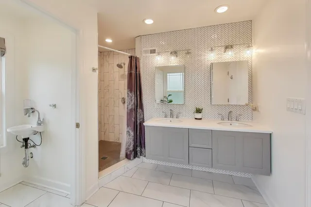 a bathroom with a double vanity sink mirror and shower