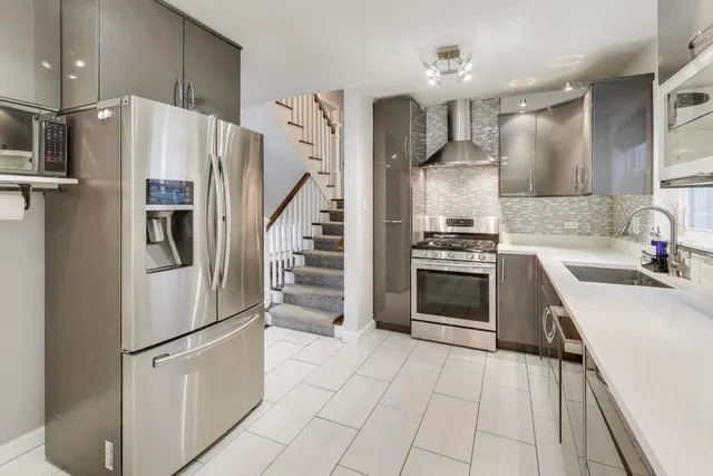 a kitchen with granite countertop a refrigerator and a sink