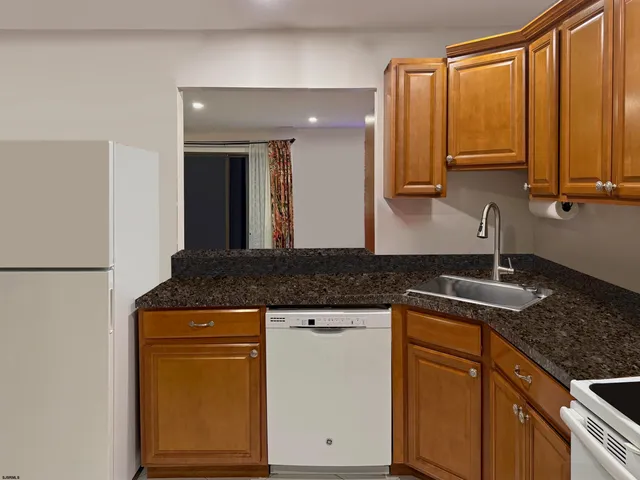 a kitchen with stainless steel appliances granite countertop a sink and a refrigerator