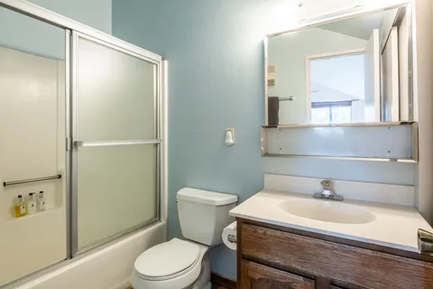 a bathroom with a sink a toilet and shower