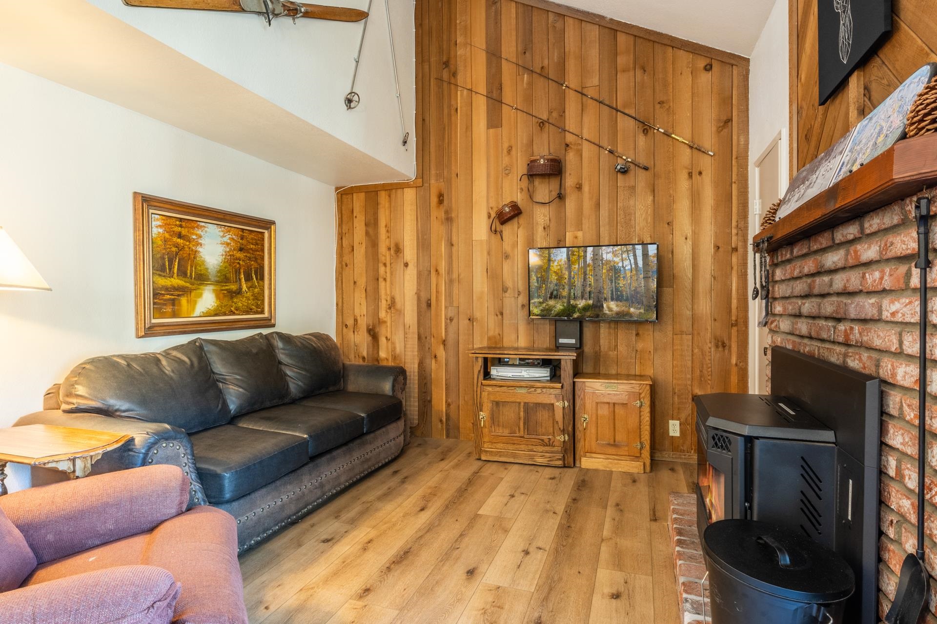 153 Lake Mary Road, Unit 132 Mammoth Lakes, CA 93546 - Photo 4 of 32 Living room featuring wood walls, wood-type flooring, and a wood stove