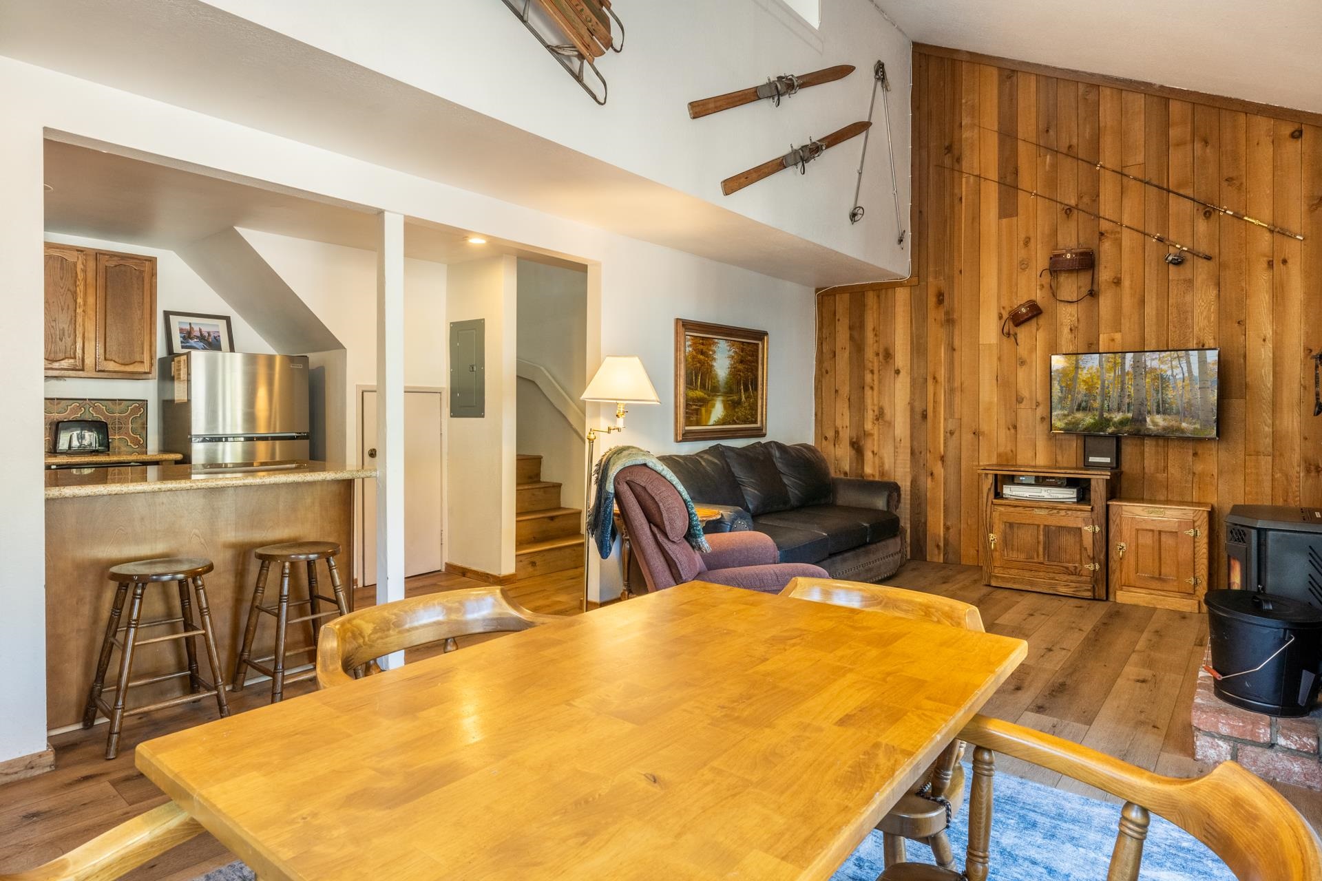 153 Lake Mary Road, Unit 132 Mammoth Lakes, CA 93546 - Photo 6 of 20 Dining space with wooden walls, stairs, light wood finished floors, a wood stove, and electric panel