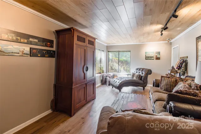 a view of a hallway with wooden floor and furniture