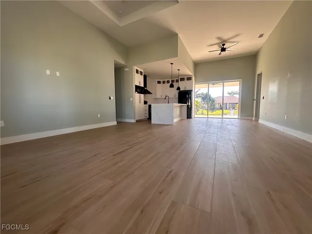 a view of a big room with wooden floor and windows