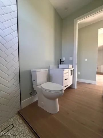 a white toilet sitting next to a white sink and vanity