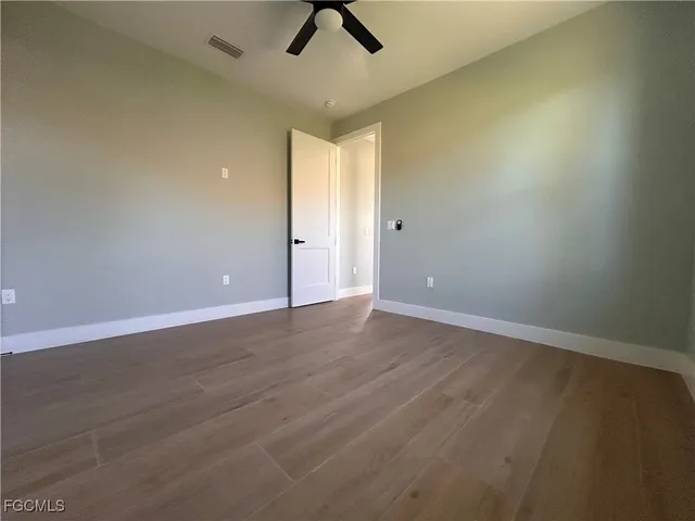 an empty room with view of a ceiling fan and hardwood floor