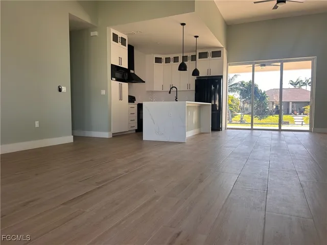 an empty room with fireplace wooden floor and windows