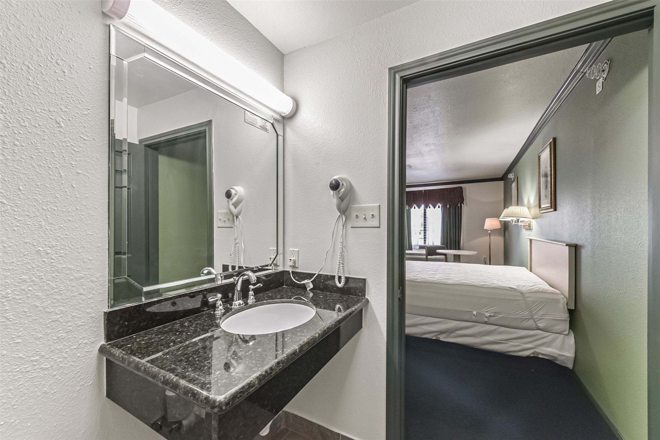 1025 Swanson Street, Unit 314 Houston, TX 77030 - Photo 17 of 25 a en suite bathroom with a granite countertop sink and a mirror