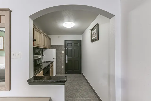 a kitchen with granite countertop a refrigerator stove and microwave