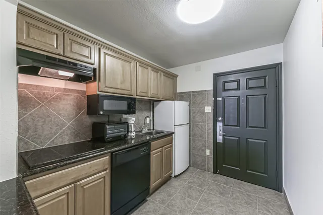 a kitchen with stainless steel appliances granite countertop a sink stove and cabinets