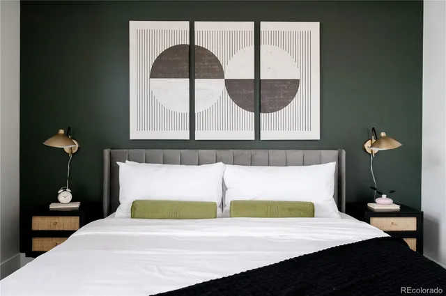 a bedroom with a bed and a painting on the wall