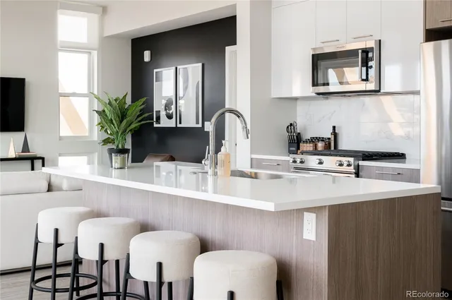 a dining table with chairs and white cabinets