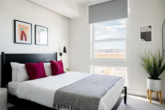 a bedroom with a large bed and a potted plant