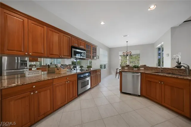 a large kitchen with granite countertop a sink dishwasher stove and cabinets