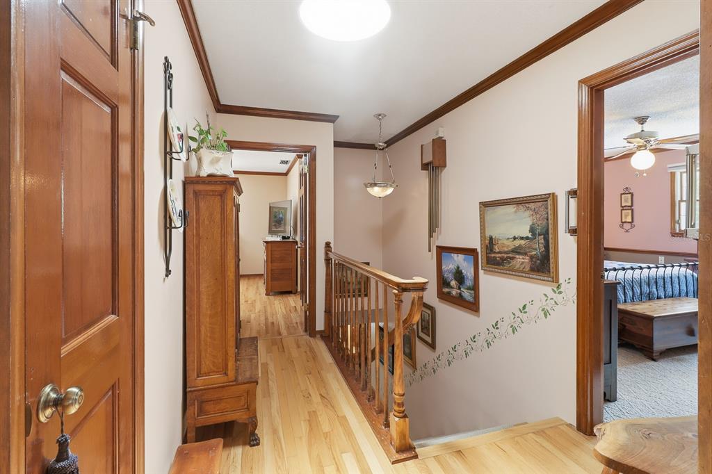 6491 Spruce Creek Road Port Orange, FL 32127 - Photo 24 of 73 a view of a hallway with wooden floor and staircase