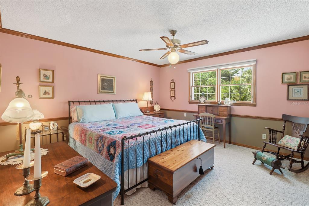 6491 Spruce Creek Road Port Orange, FL 32127 - Photo 25 of 73 a bedroom with a bed a chair and next to a window
