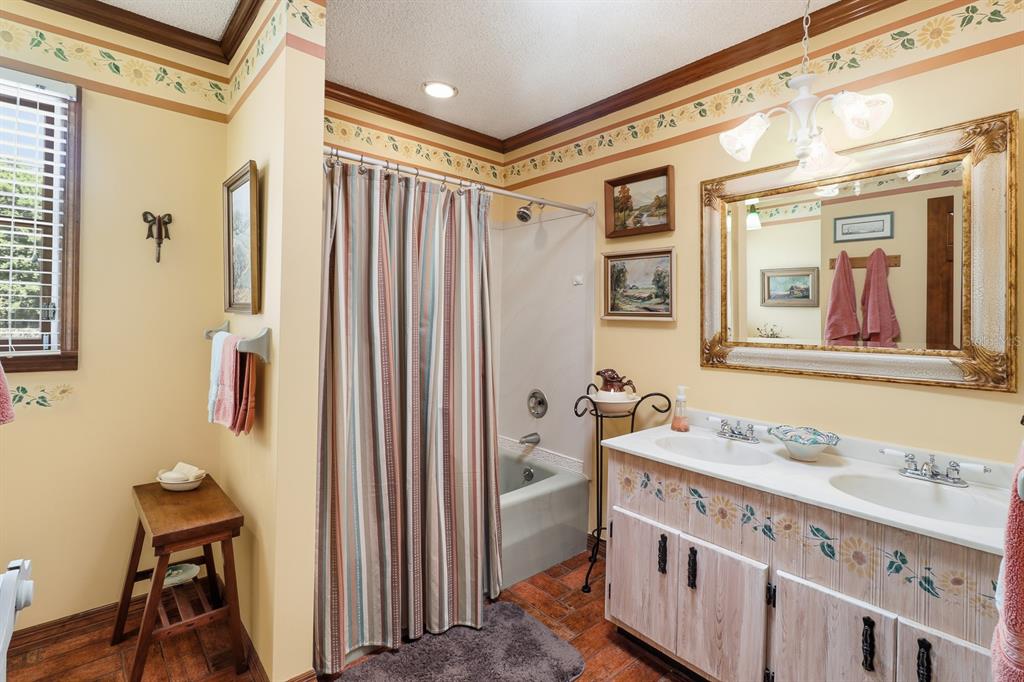 6491 Spruce Creek Road Port Orange, FL 32127 - Photo 27 of 73 a bathroom with a sink a mirror and a shower