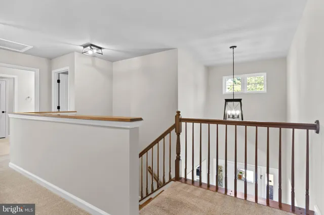 a view of a hallway with windows and chandelier