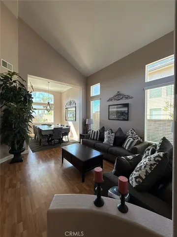 a living room with furniture hard wood floor and a window