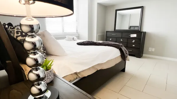 a bedroom with a bed mirror and a window