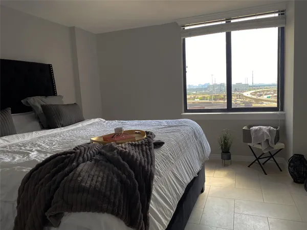 a bedroom with a bed and large windows