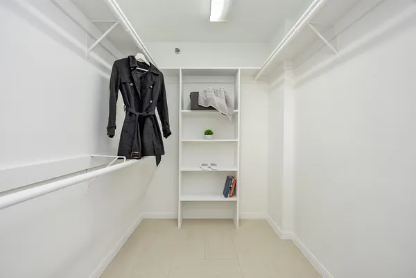 a view of walk in closet with clothes and shoes